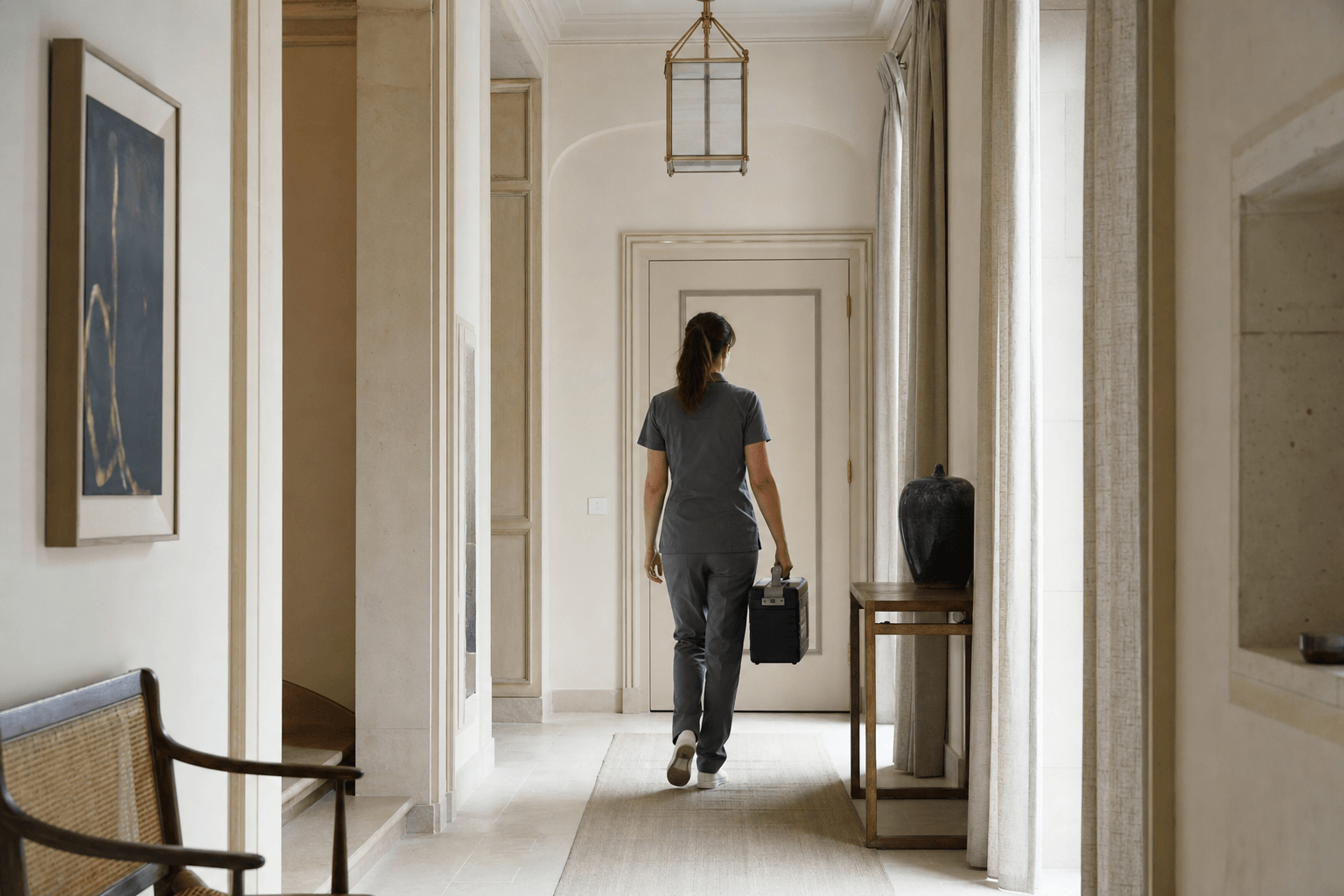 Couloir d'appartement calme, intervenant discret de dos avec une mallette de matériel